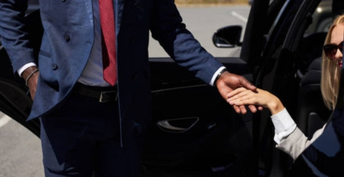 Chauffeur assisting client out of car, providing attentive service with Orlando airport taxi service.